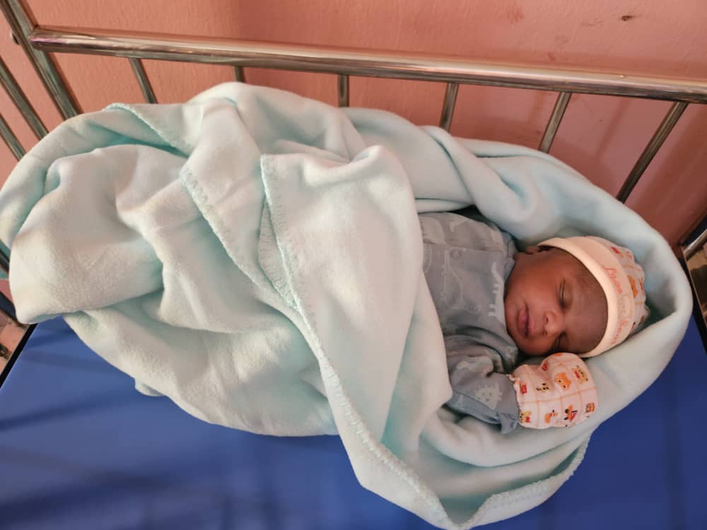 Newborn baby swaddled and sleeping peacefully